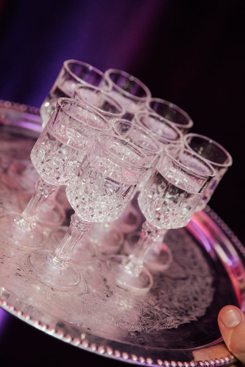 Cut-crystal goblets on a silver tray under violet light