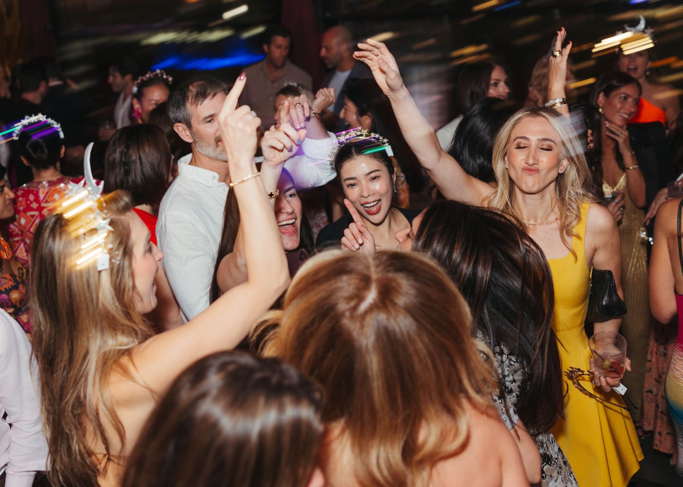 A dance floor of guests in glowing crowns