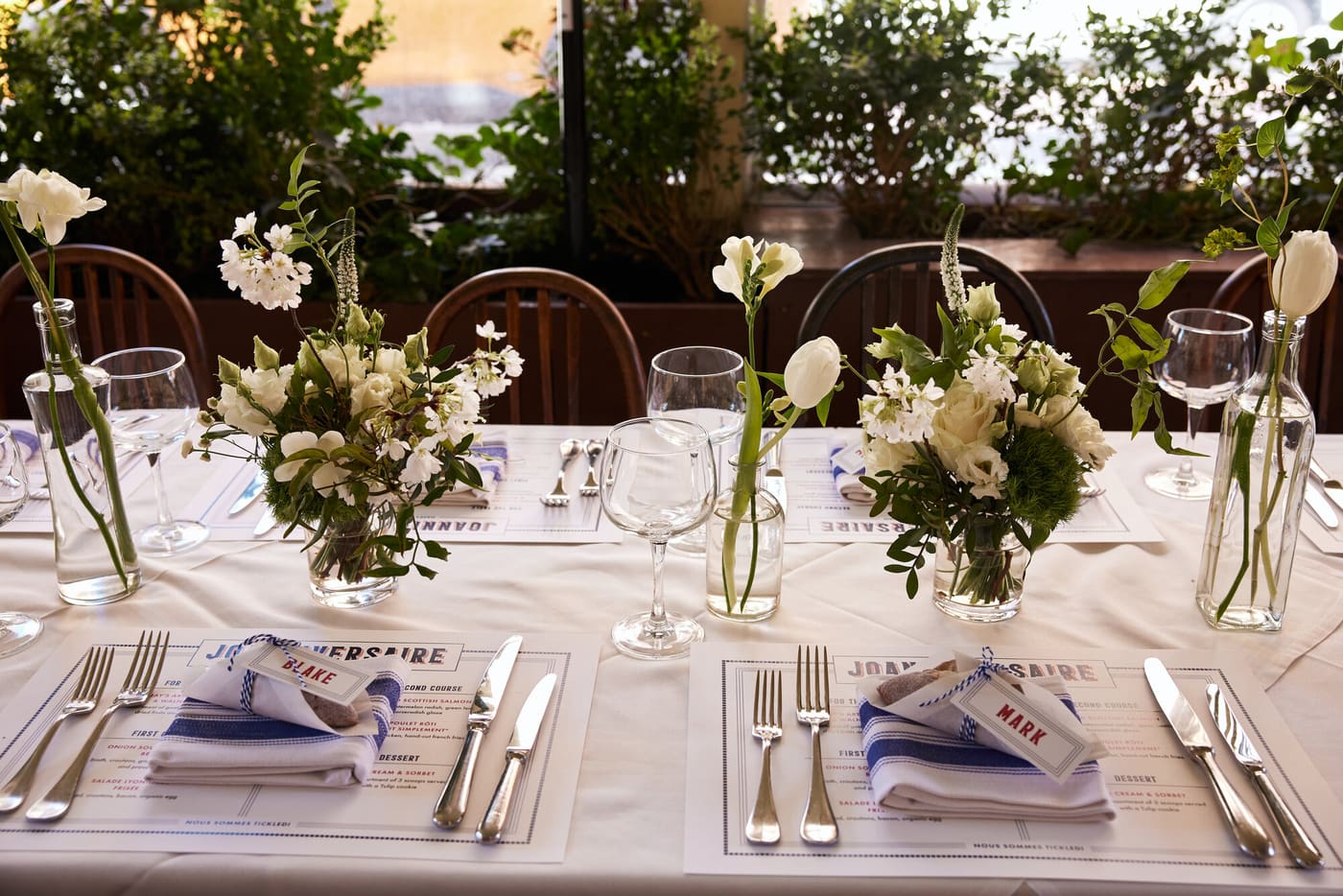 A daylight lunch table of white florals and striped napkins